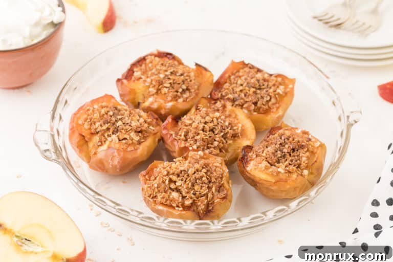 A plate of air fryer baked apples with oat filling and a spoon.
