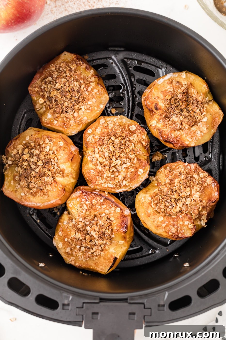 Baked apple with oat filling inside an air fryer basket.