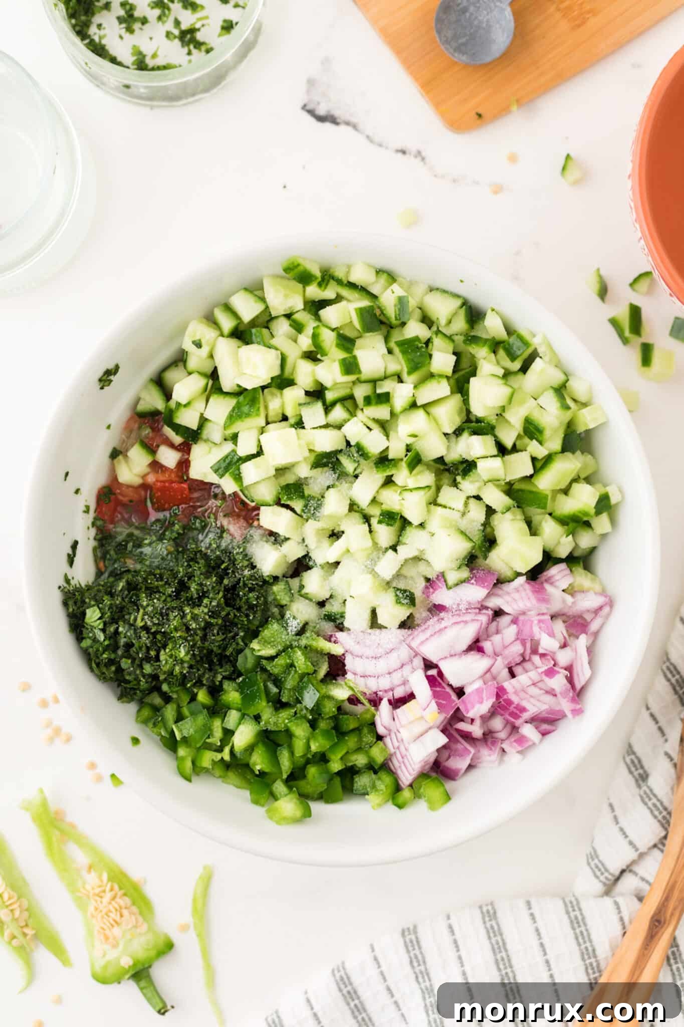 chopped cucumber in a bowl for cucumber salsa, mixed with other ingredients.