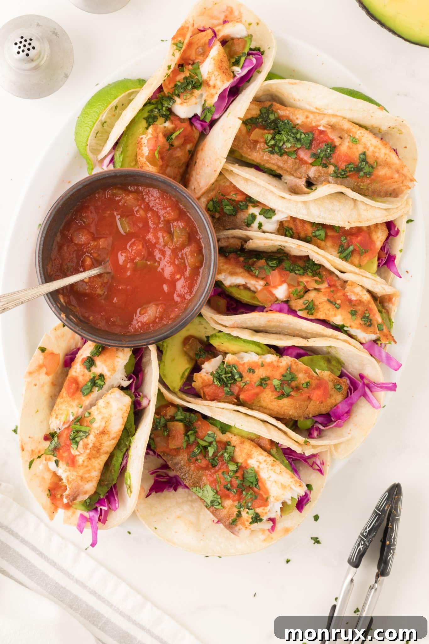 air fryer fish tacos served with avocado and salsa.