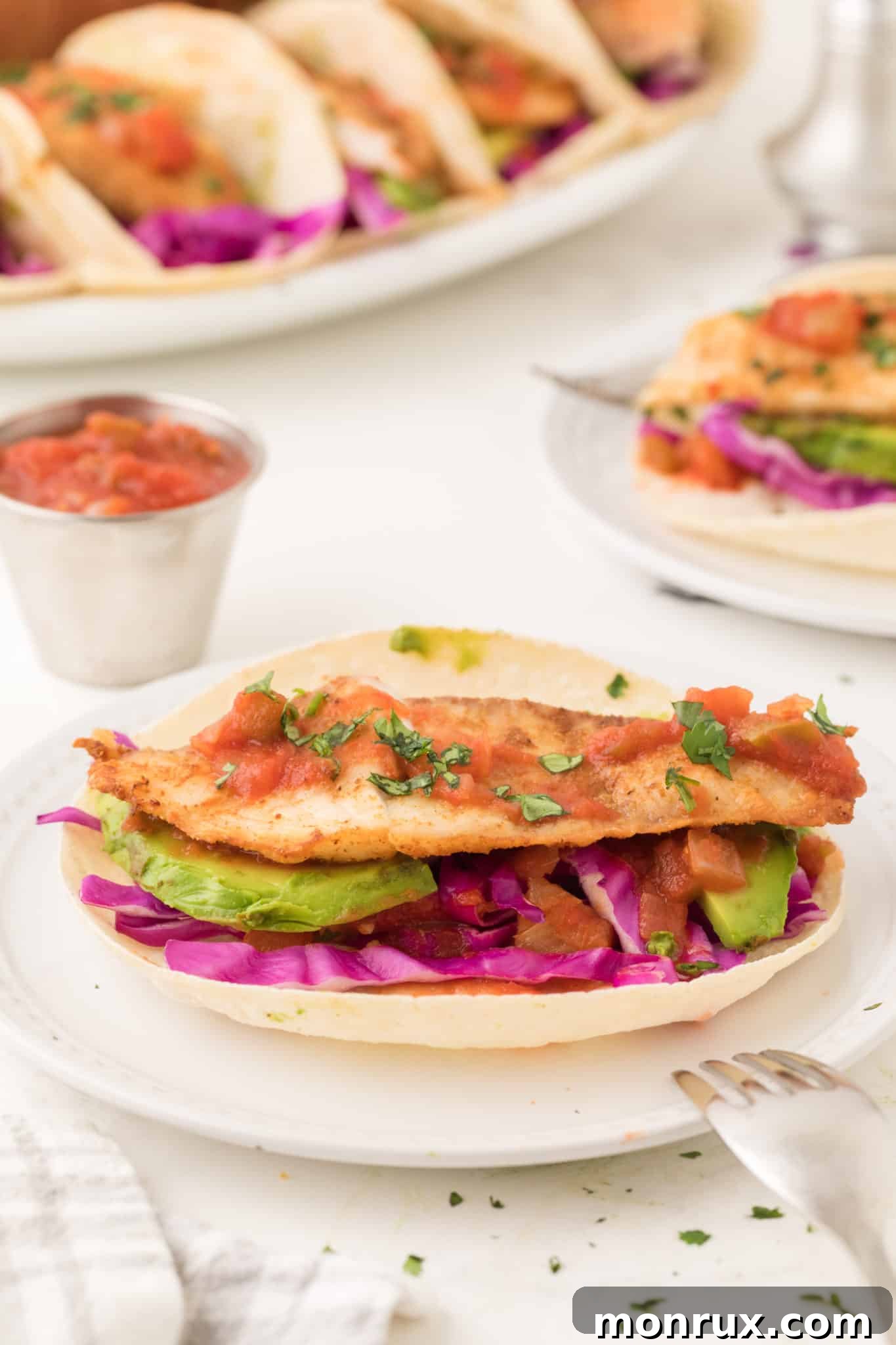 A fish taco with salsa and avocado.