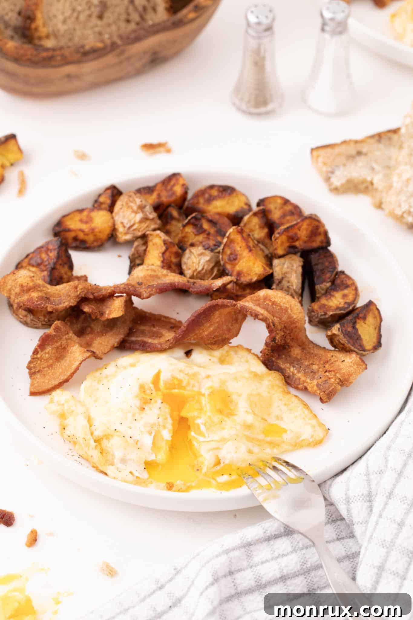 Over medium eggs served with bacon and potatoes.