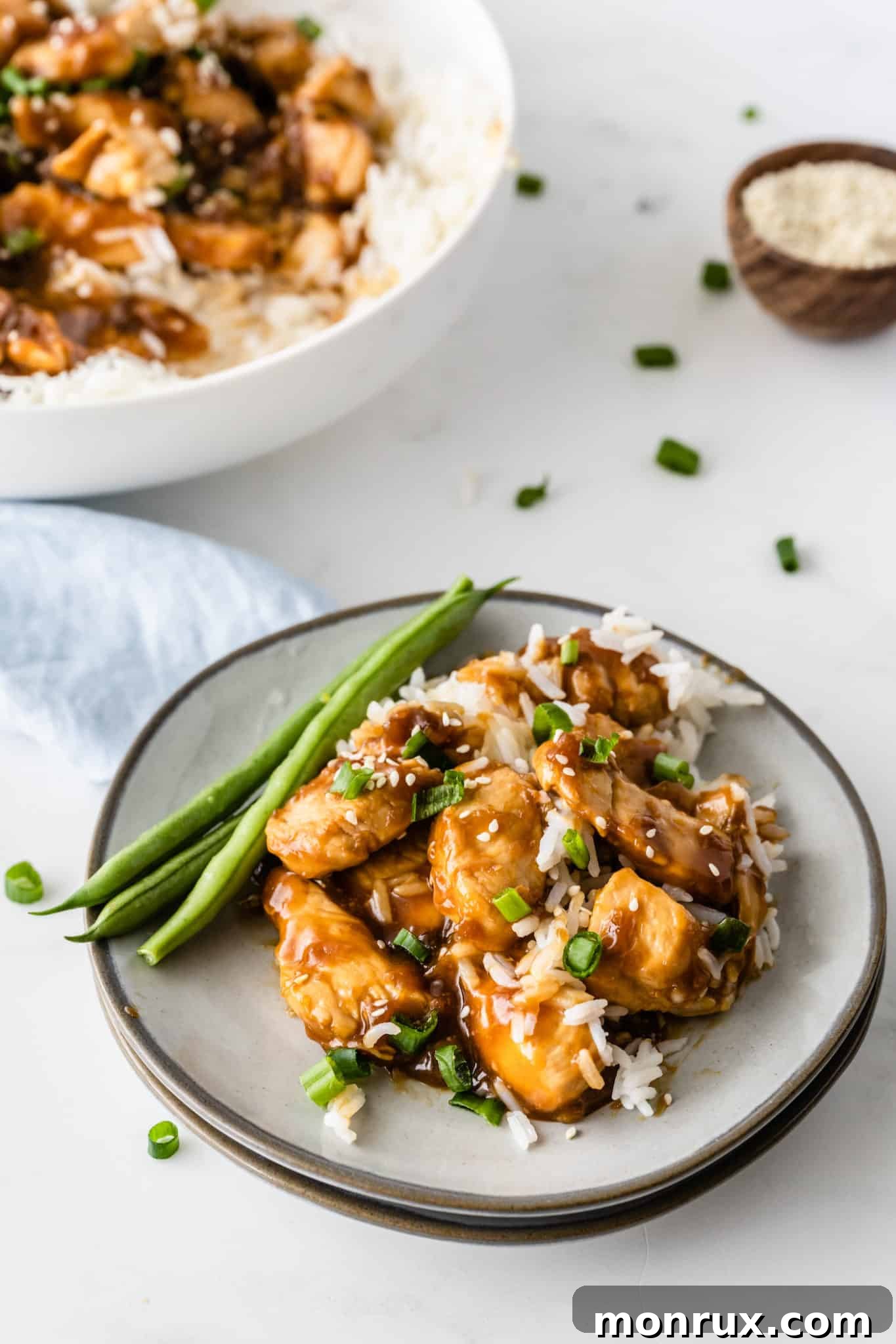 Gluten-free teriyaki chicken with rice served with green beans, garnished with sesame seeds