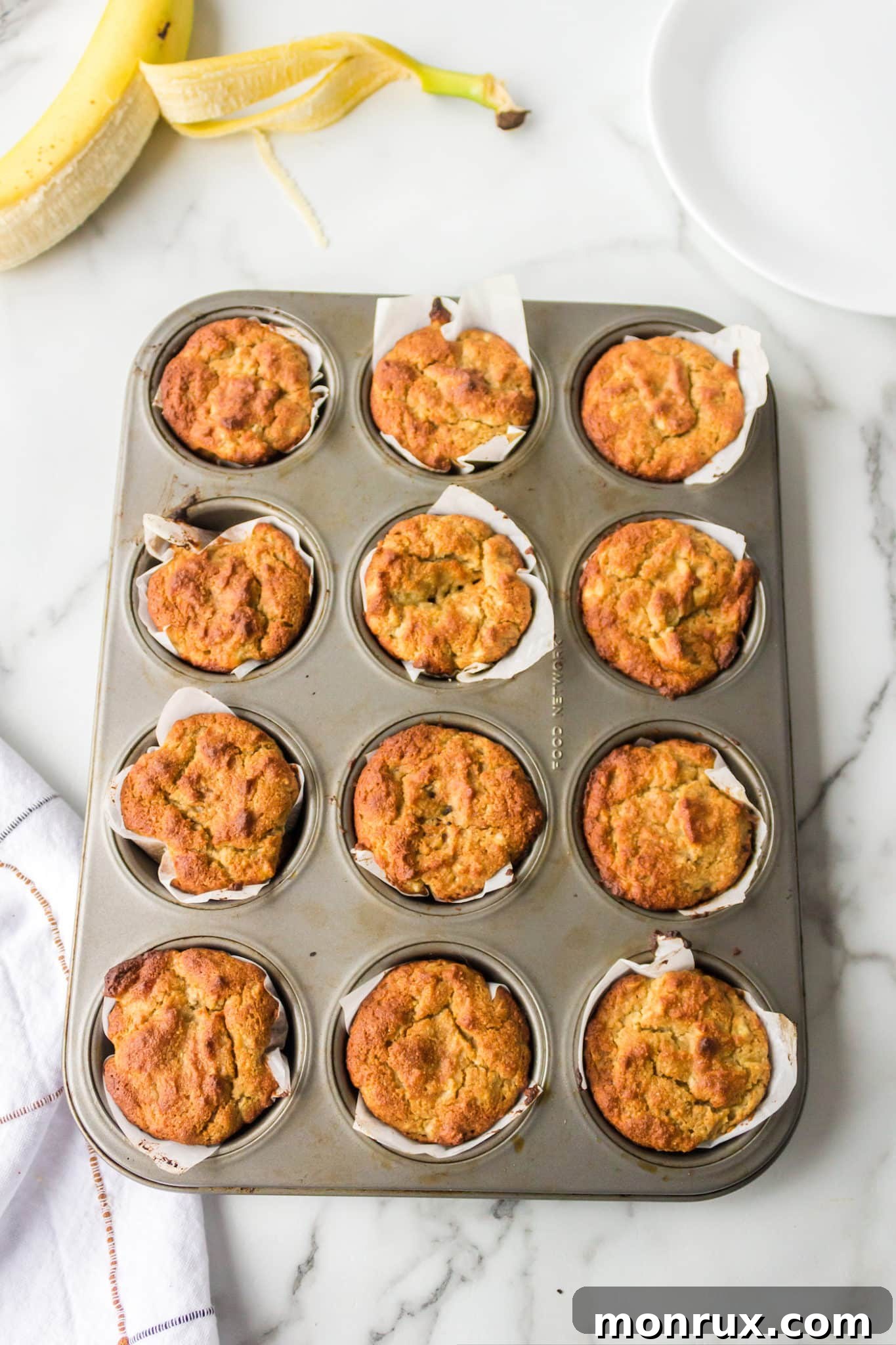 Freshly baked almond flour banana muffins still in the muffin tin, cooling down.