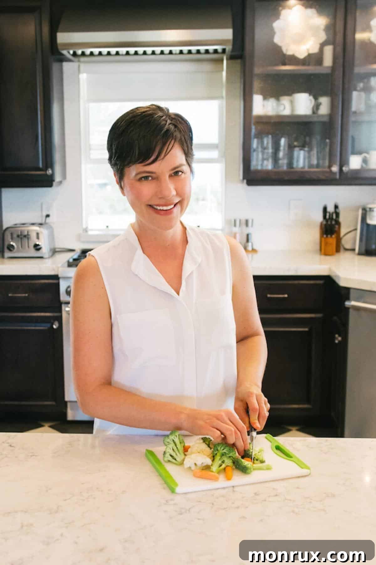 Carrie Forrest, a nutritionist and blogger, is shown expertly chopping vegetables in her bright, clean kitchen.