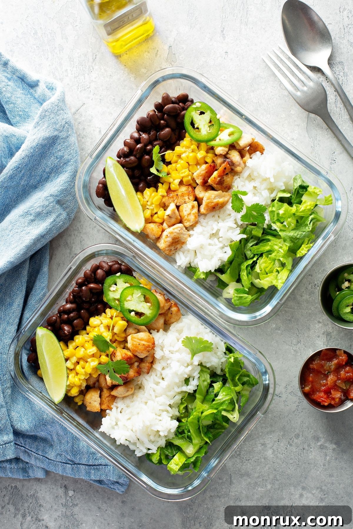 Organized meal prep containers with chicken, beans, and rice, signifying healthy, planned eating.