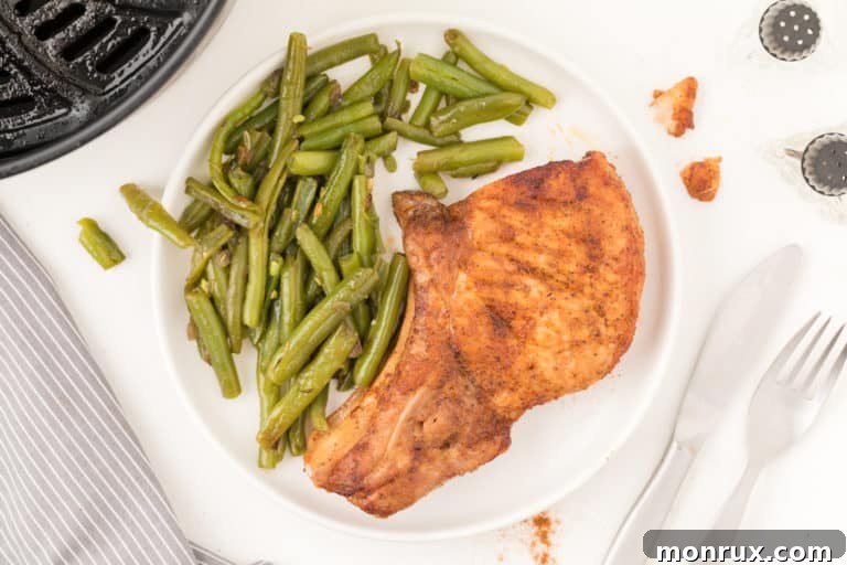 Pork chops served with green beans on a white plate