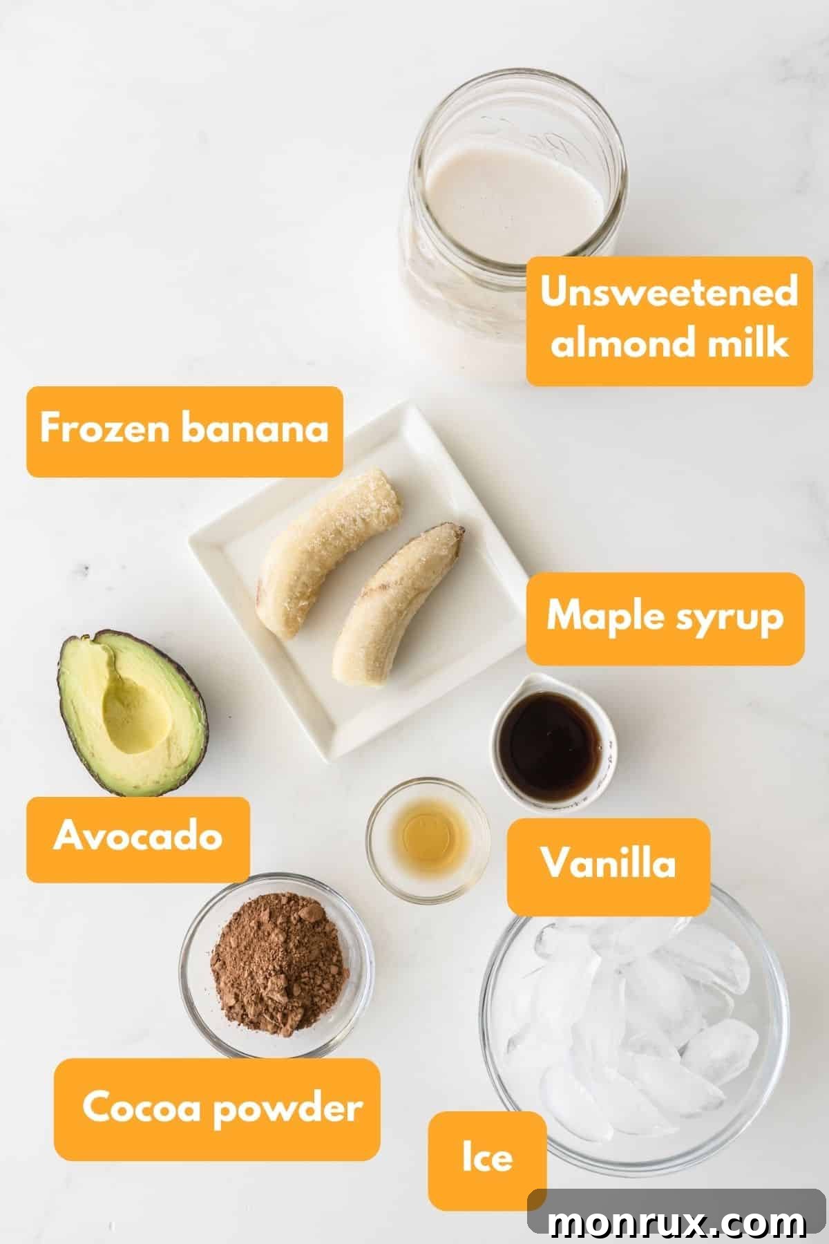 Ingredients for a chocolate avocado smoothie laid out on a wooden surface.