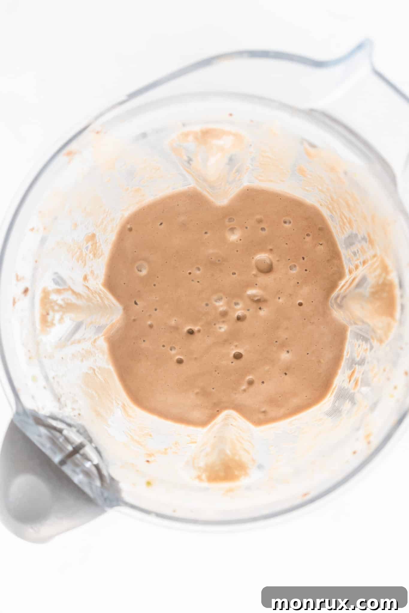 Chocolate smoothie with avocado being blended in a blender.