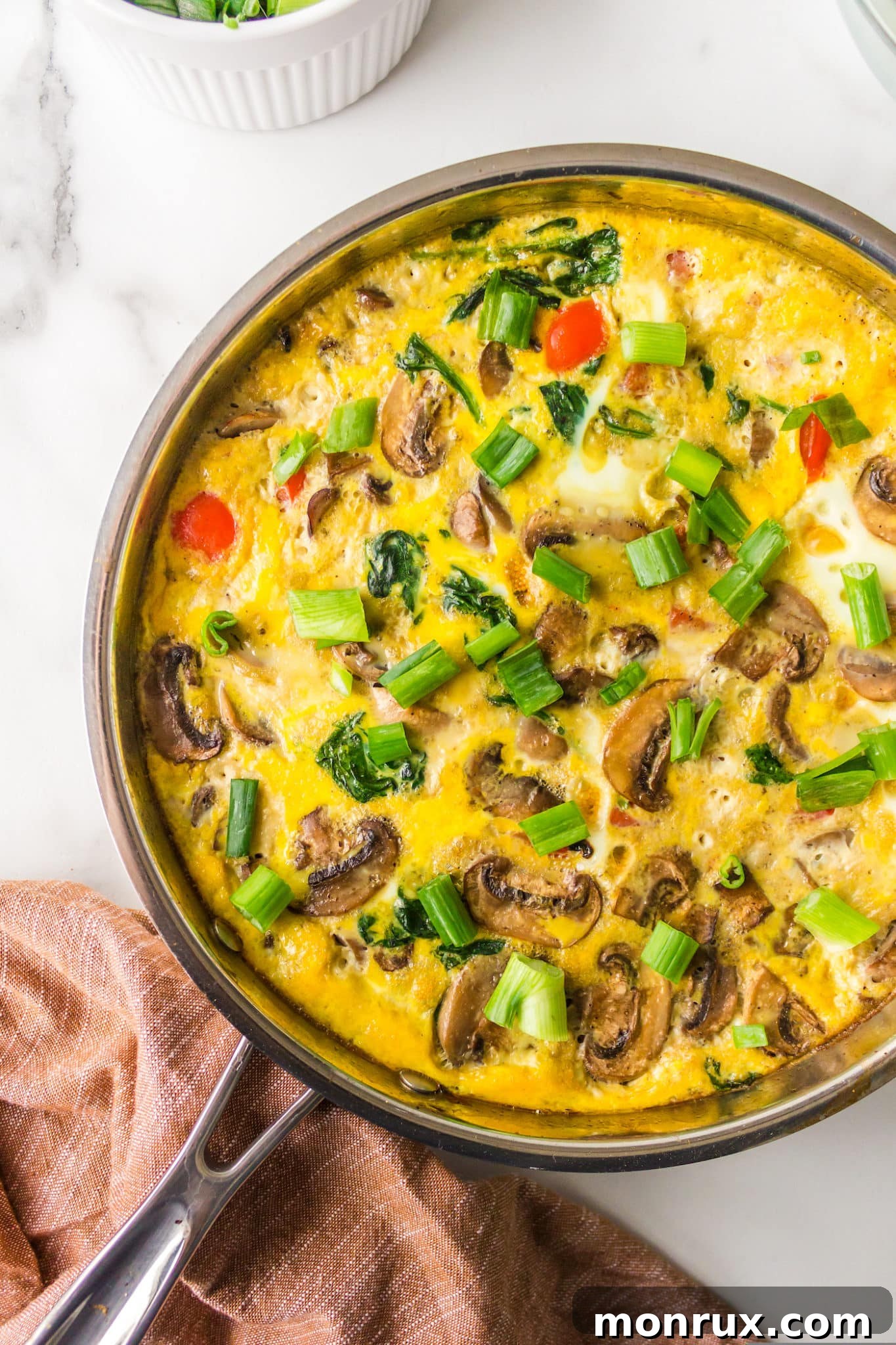 A vibrant vegetable gluten-free frittata, perfectly baked in a skillet, showcasing colorful ingredients.