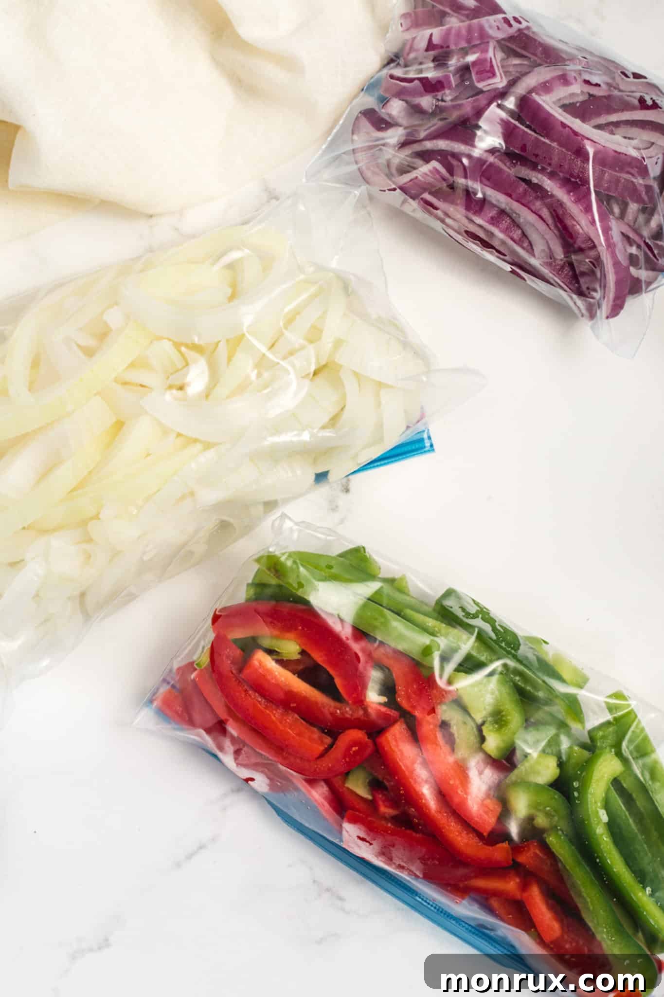 A bag of vibrant, sliced bell peppers and onions, perfectly prepped for freezing.