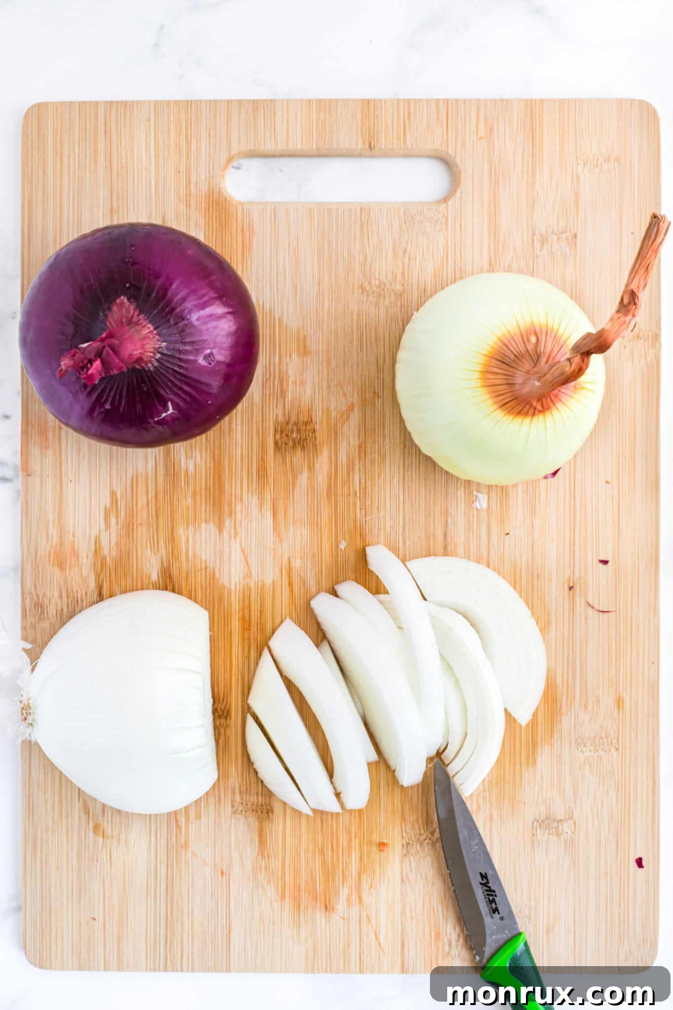 A perfectly sliced onion on a wooden cutting board, ready for freezing.