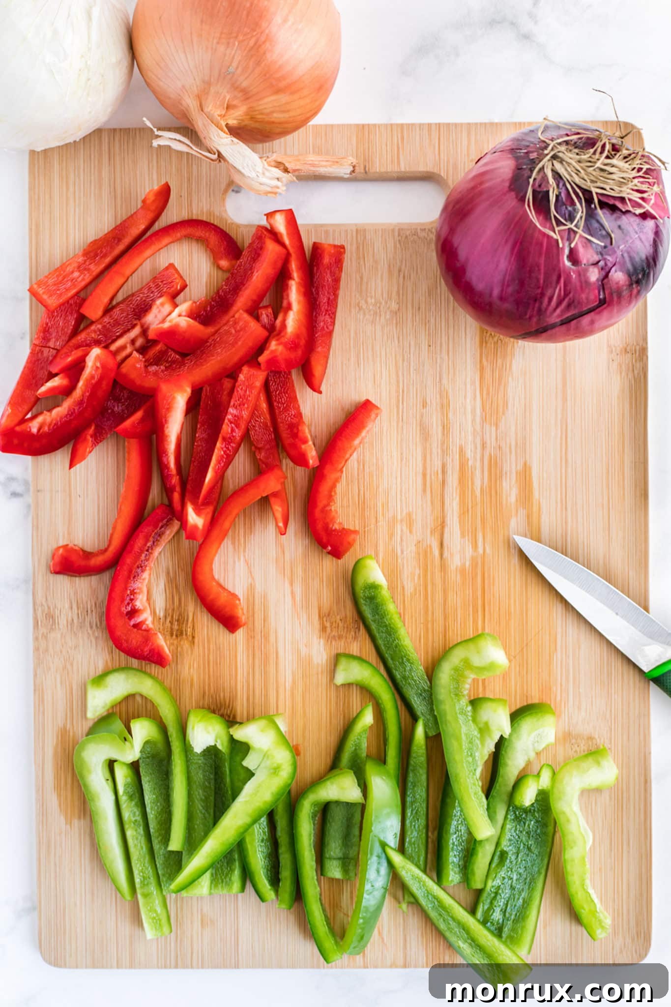 Brightly colored, sliced bell peppers neatly arranged on a cutting board.