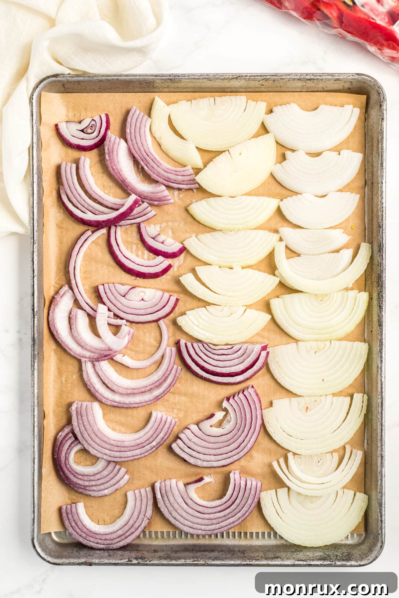 A baking sheet filled with individually frozen sliced onions.