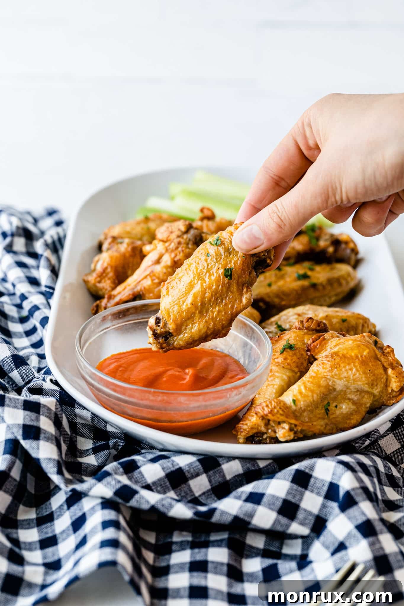 A crispy chicken wing dipped in homemade buffalo sauce.