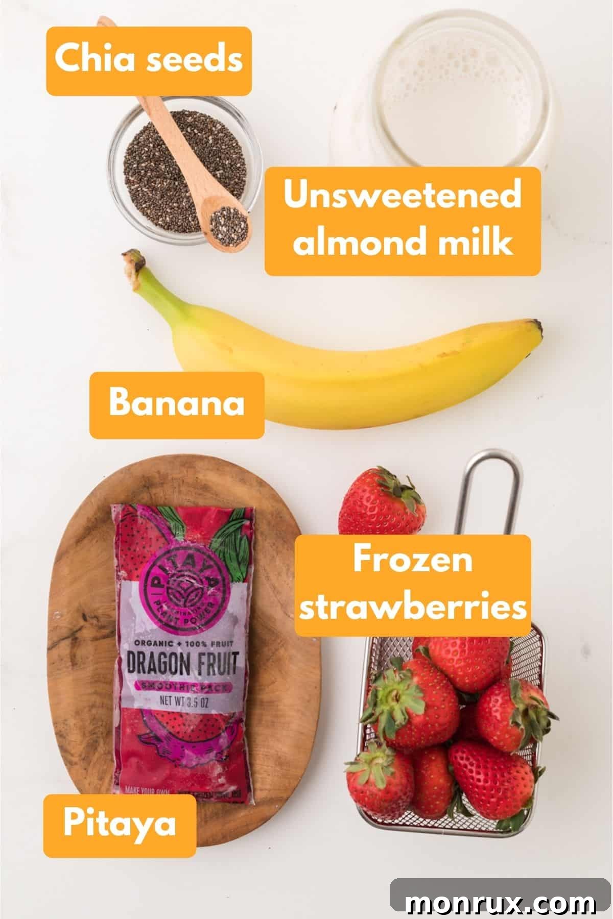A flat lay photo showing the individual ingredients for a purple dragon fruit banana smoothie: almond milk, banana, frozen dragon fruit packet, frozen strawberries, and chia seeds.