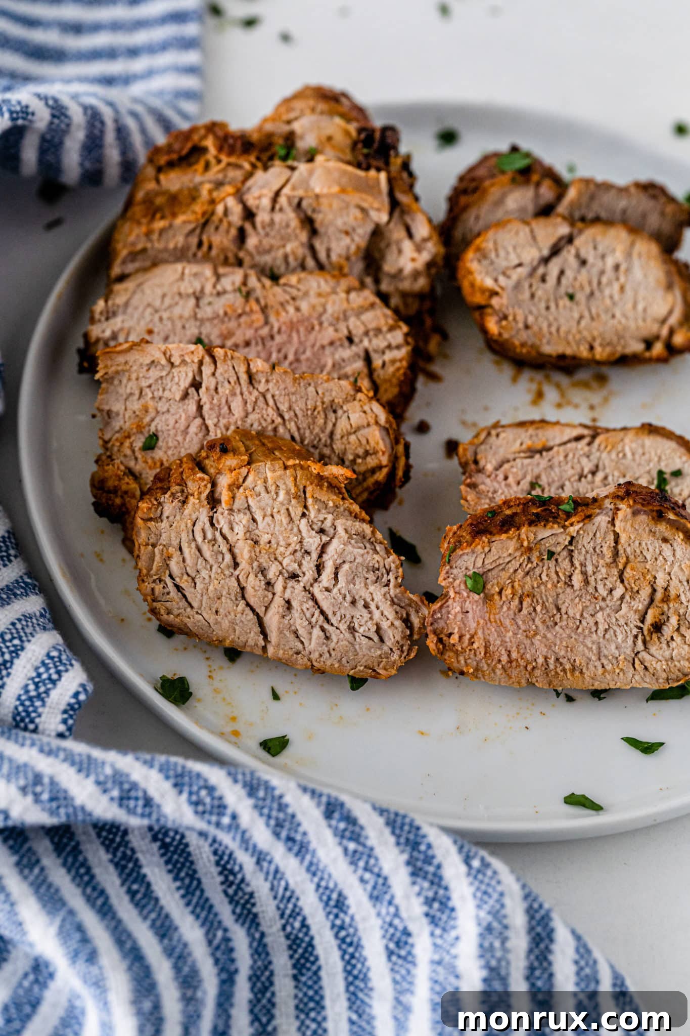 Sliced air-fried pork loin roast presented beautifully on a serving plate, ready to be enjoyed.