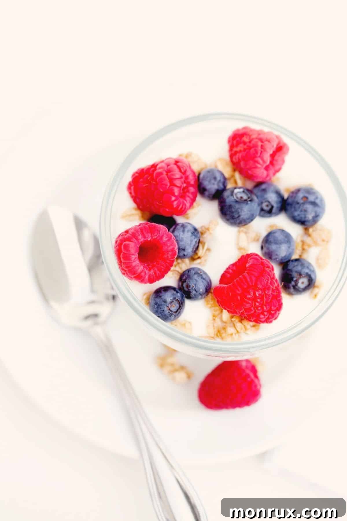 A bowl of luscious coconut yogurt generously topped with a medley of fresh, colorful berries, ready to be enjoyed.