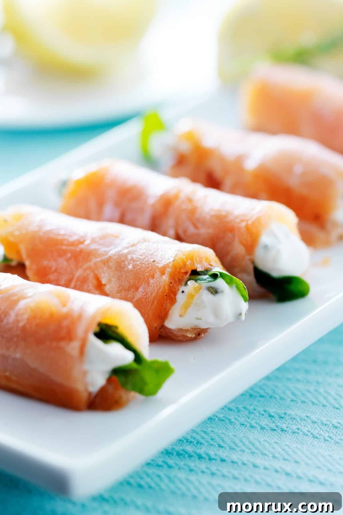 Delicious smoked salmon wraps beautifully arranged on a white plate, offering an elegant and healthy snack.