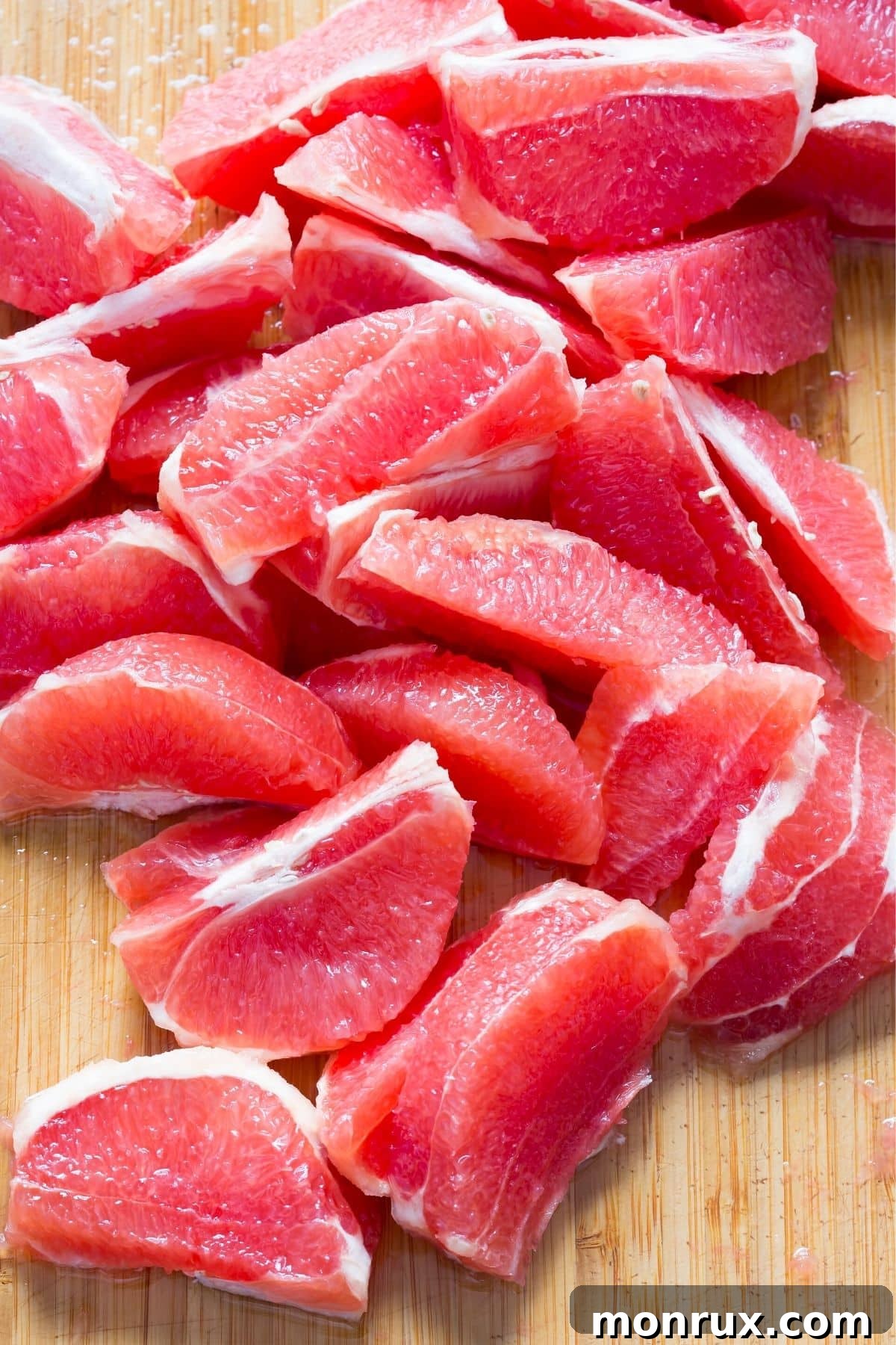 Fresh grapefruit sections beautifully arranged on a cutting board, highlighting their vibrant color and juicy texture.