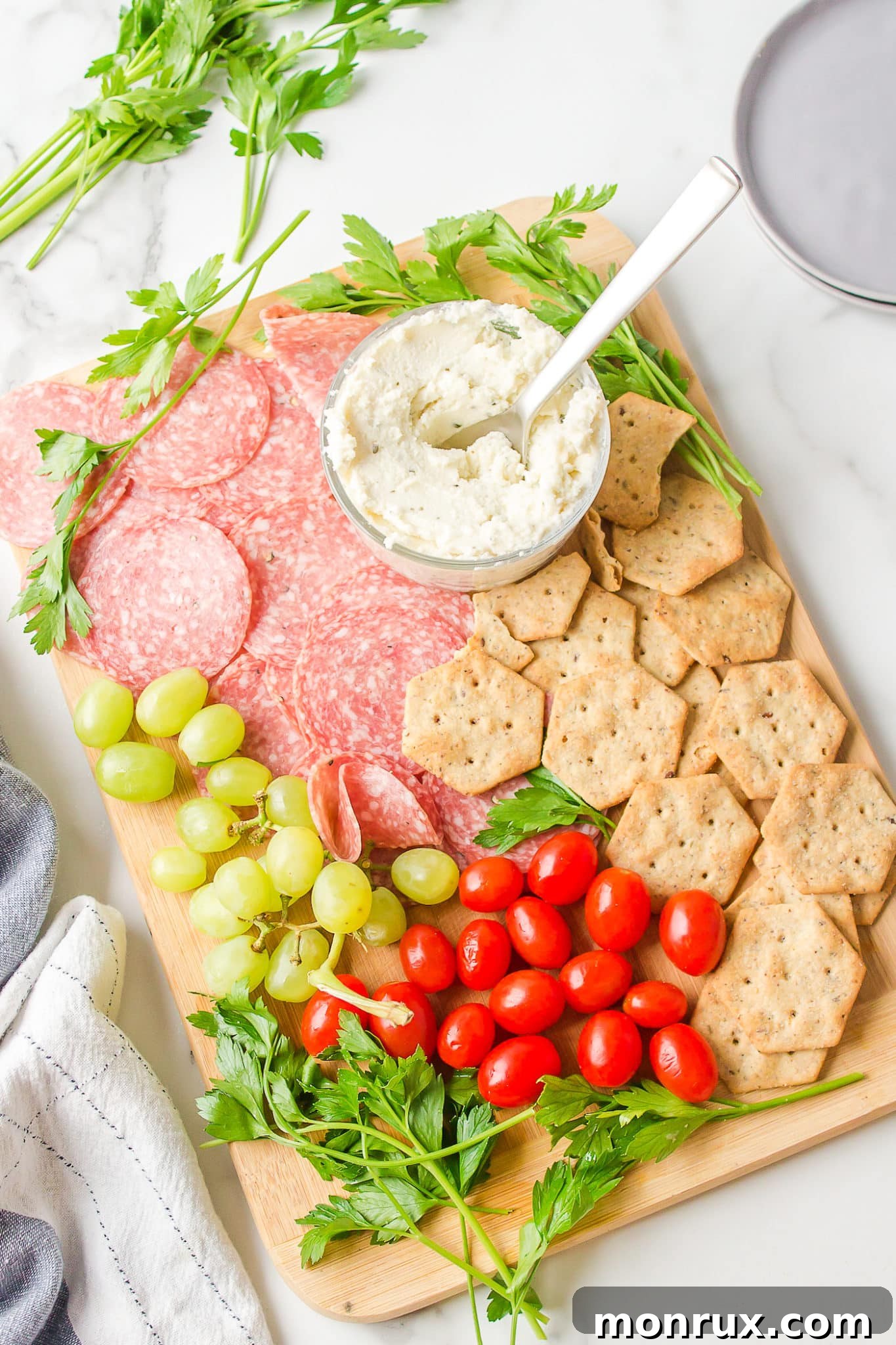 A beautifully arranged gluten-free and dairy-free charcuterie board, laden with a variety of colorful and delicious ingredients.