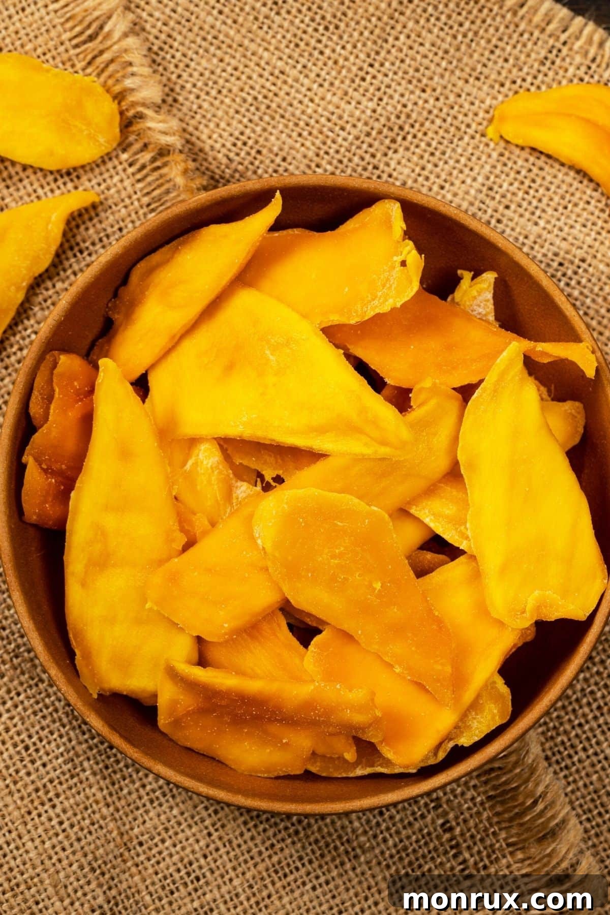 A bowl filled with delectable, golden dried mango slices, perfect for a sweet and healthy snack.