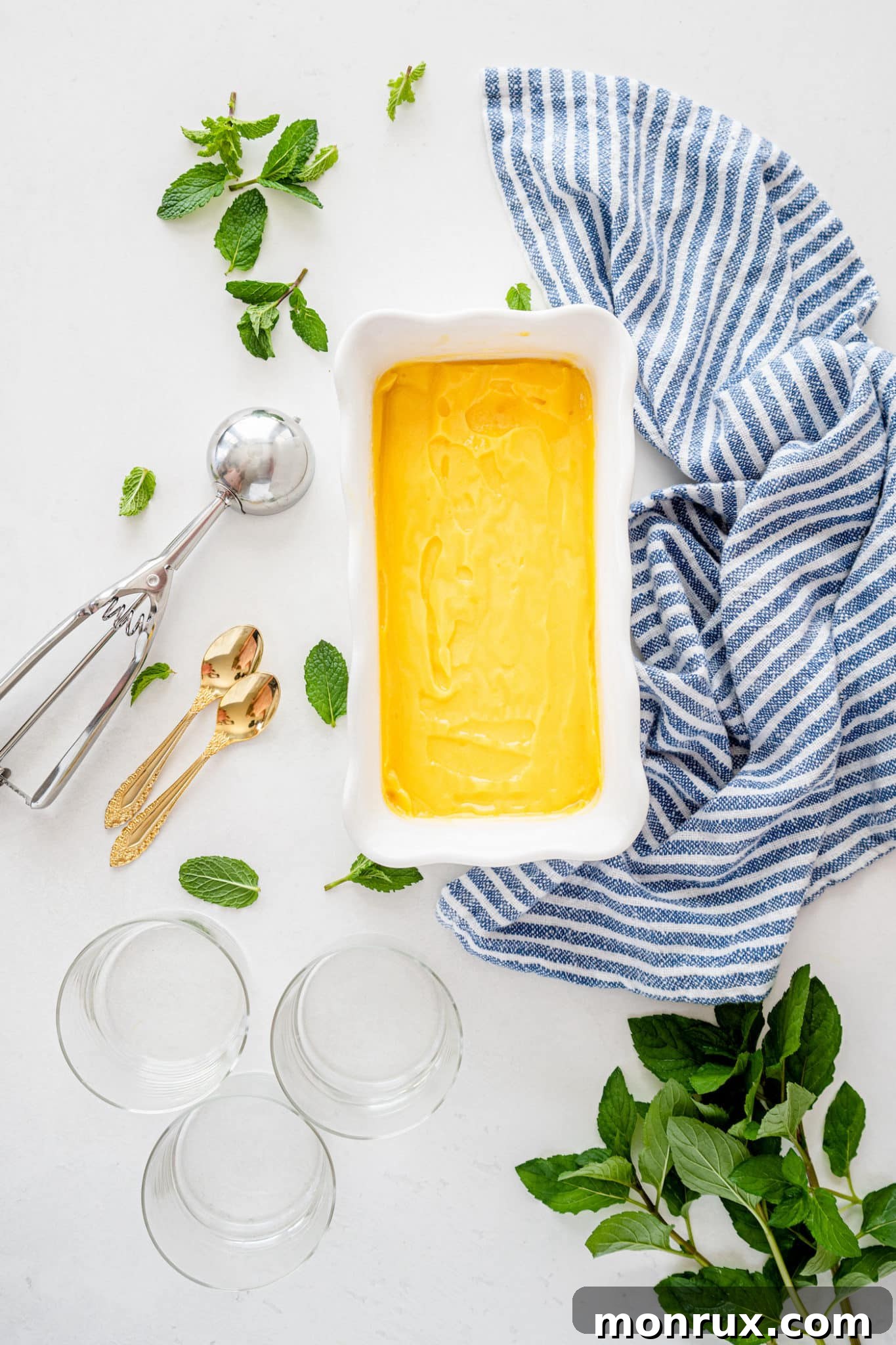 Scoops of mango sorbet neatly arranged in a freezer-safe ice cream container, ready for storage or serving.