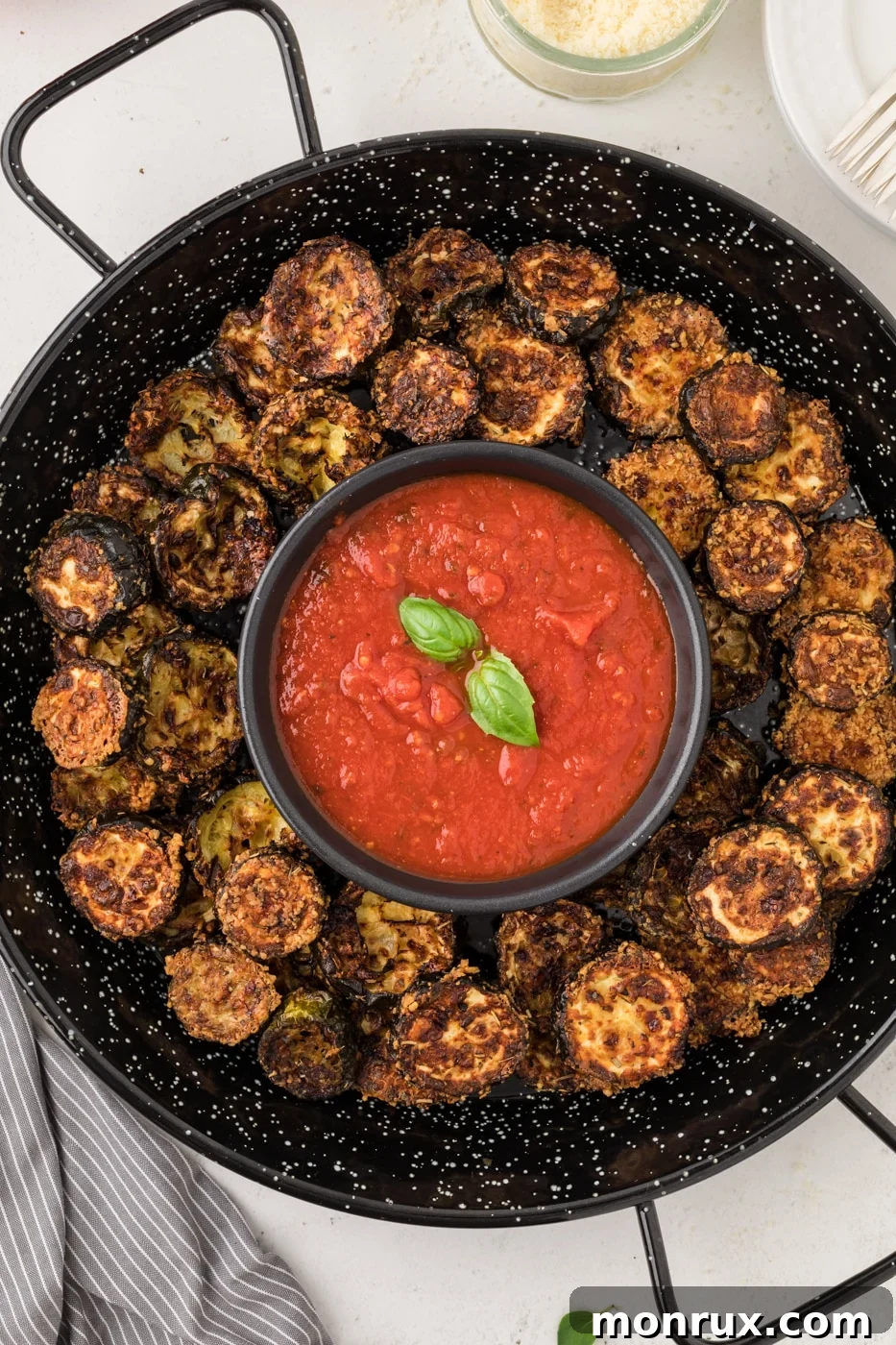 Crispy air fried zucchini chips served with a side of marinara for dipping.