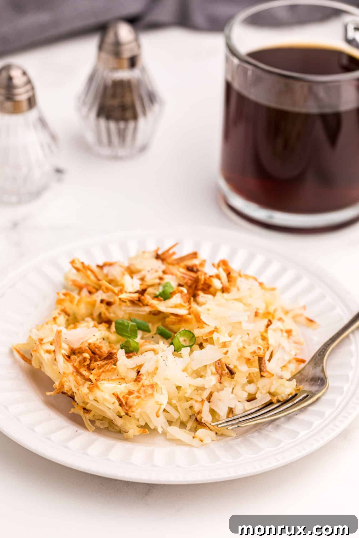 Crispy air-fried hash browns served with a steaming cup of coffee, perfect for breakfast.