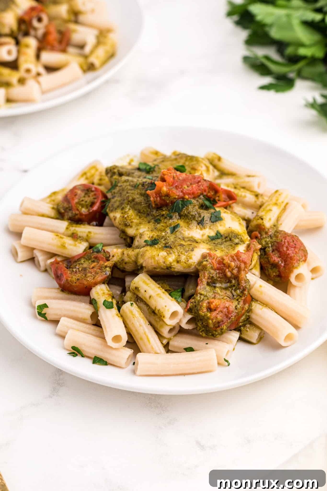 Instant Pot Pesto Chicken served with pasta and vibrant cherry tomatoes.
