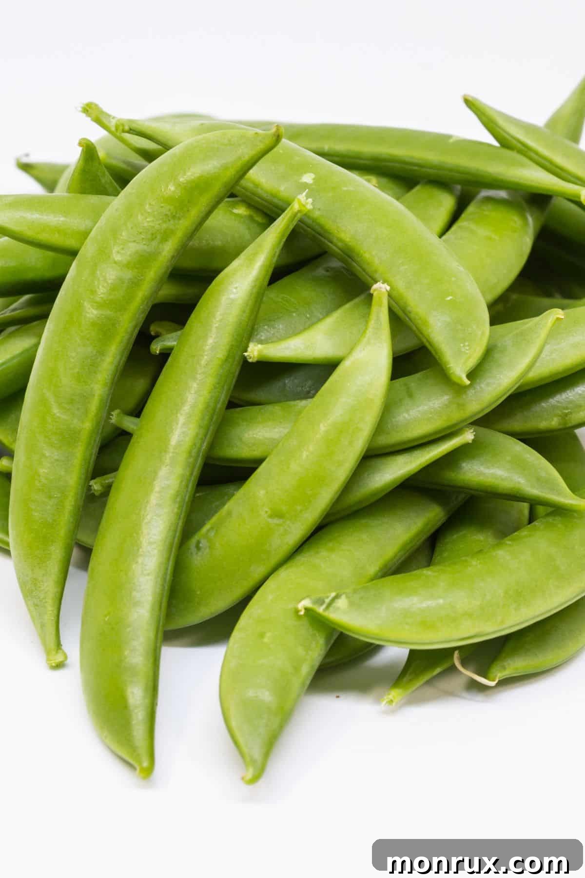 sugar snap peas on table, looking crunchy and sweet.
