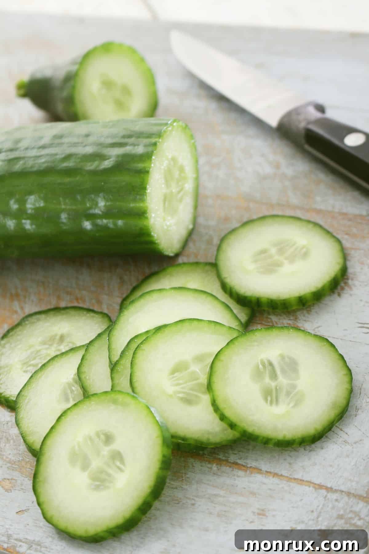 cucumber on table with knife, ready for preparation.