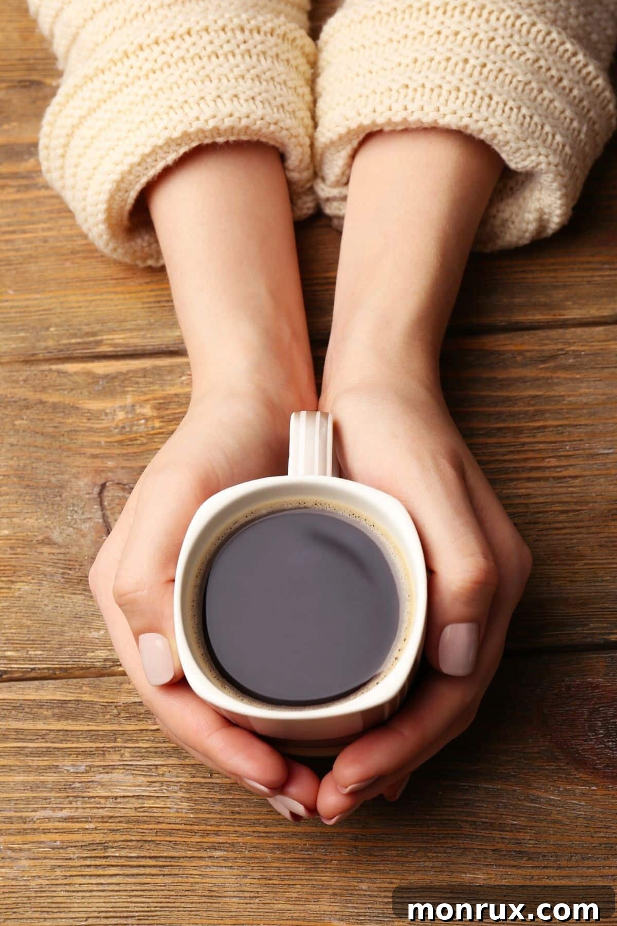 A woman's hands gently holding a warm mug of organic coffee on a clean tabletop, evoking comfort and health.