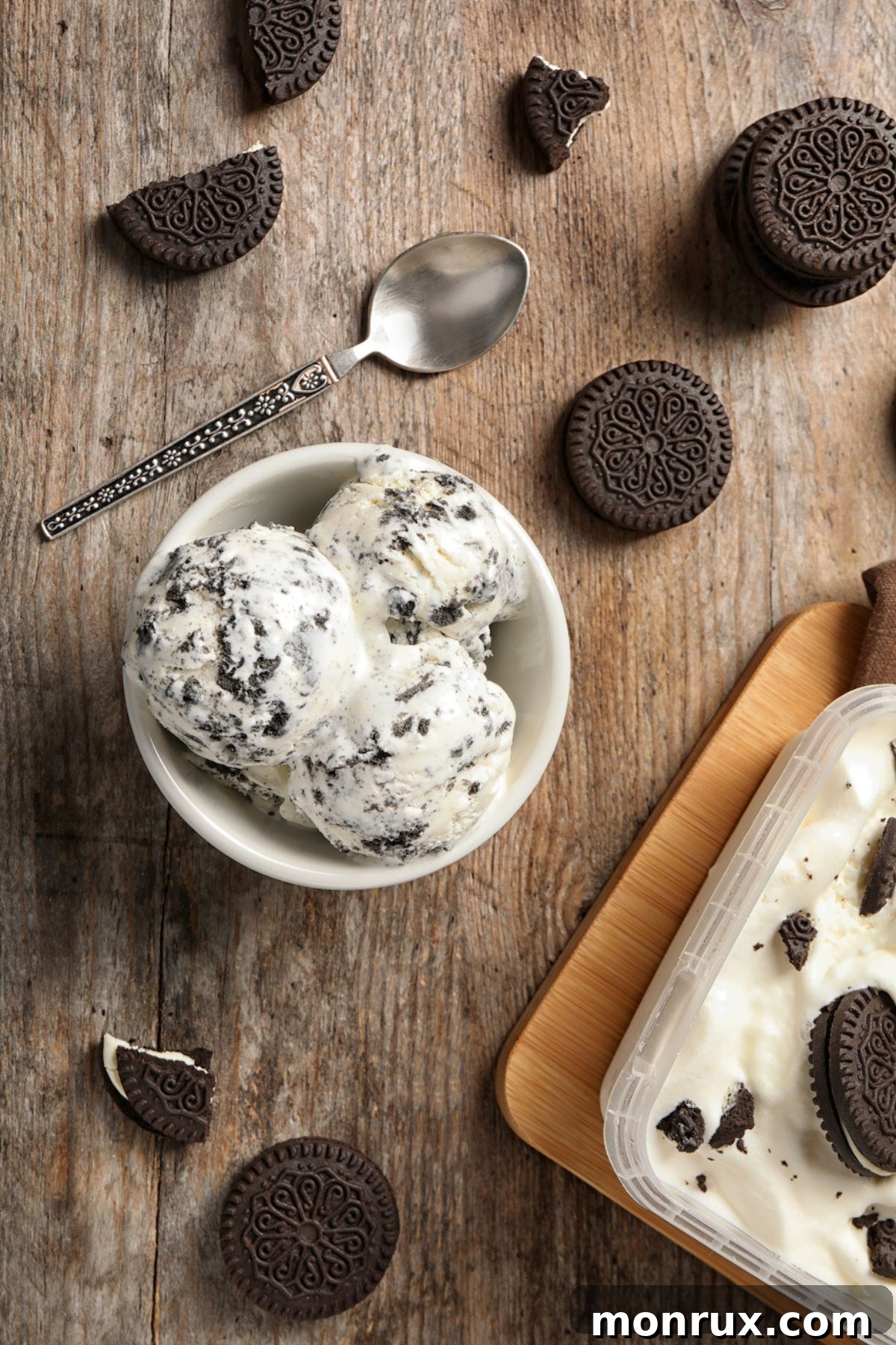 A beautiful bowl of homemade cookies and cream nice cream, garnished with cookie crumbles and served with a spoon on a rustic wooden table.