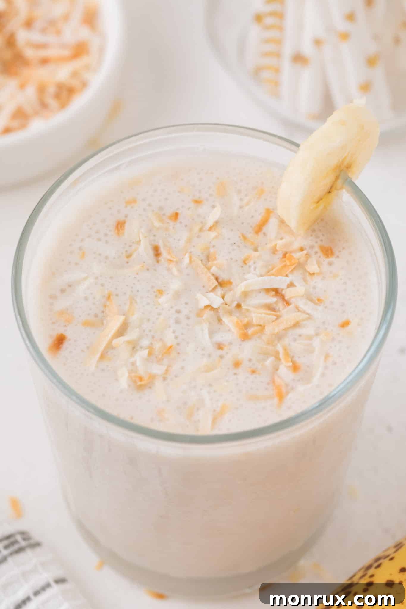 Decadent coconut shake served in a tall glass, garnished with toasted coconut flakes.