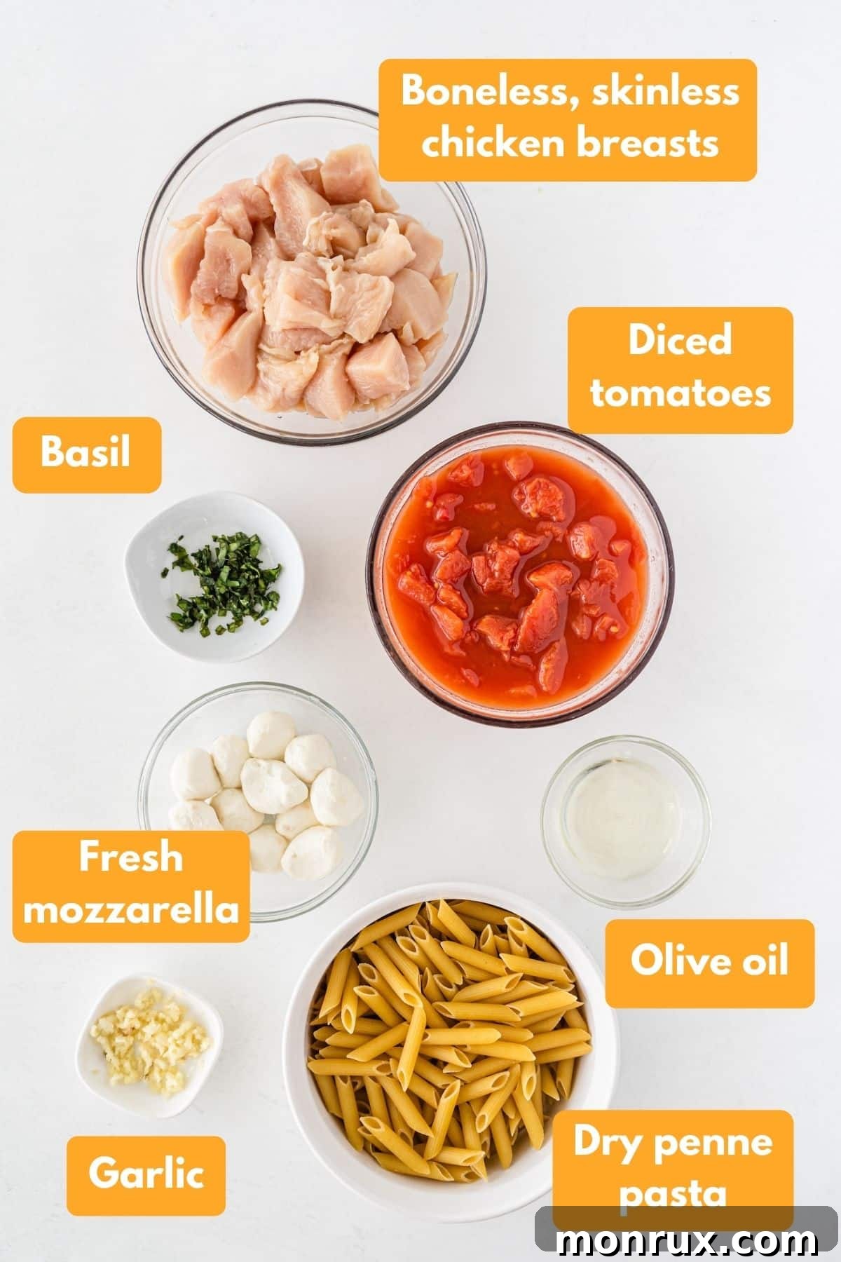 Close-up of fresh ingredients for Cheesecake Factory's Tomato Basil Pasta: penne, chicken, tomatoes, mozzarella, basil, garlic.