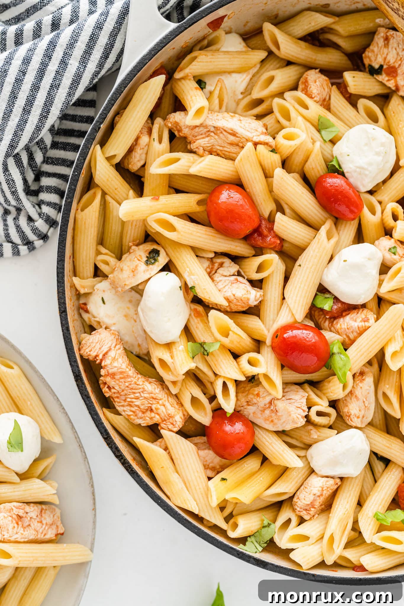 A large skillet filled with the finished tomato basil pasta and chicken, ready to be served.