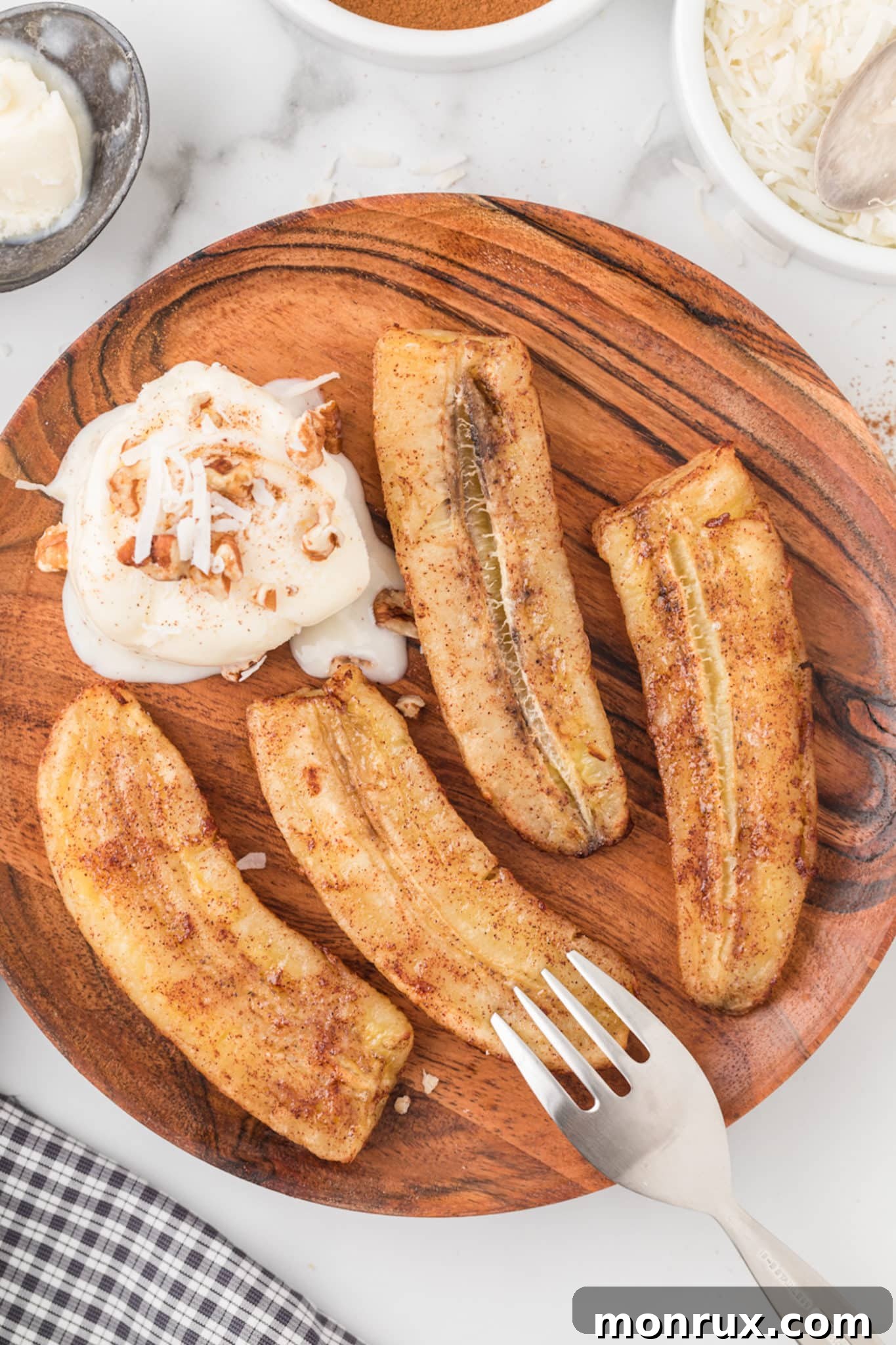 air fried bananas on a wooden plate with ice cream.