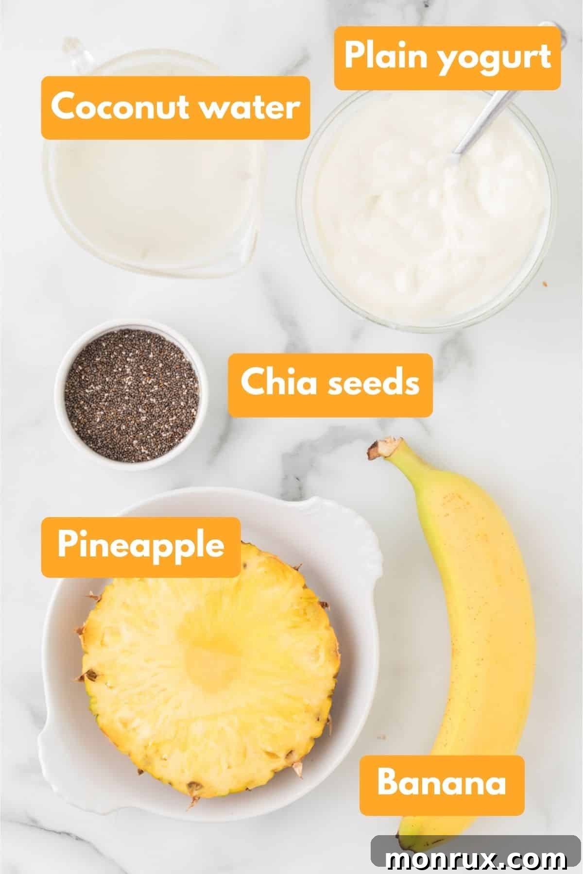 A flat lay of fresh ingredients for a pineapple banana smoothie, including coconut water, yogurt, sliced pineapple, frozen banana chunks, and chia seeds.