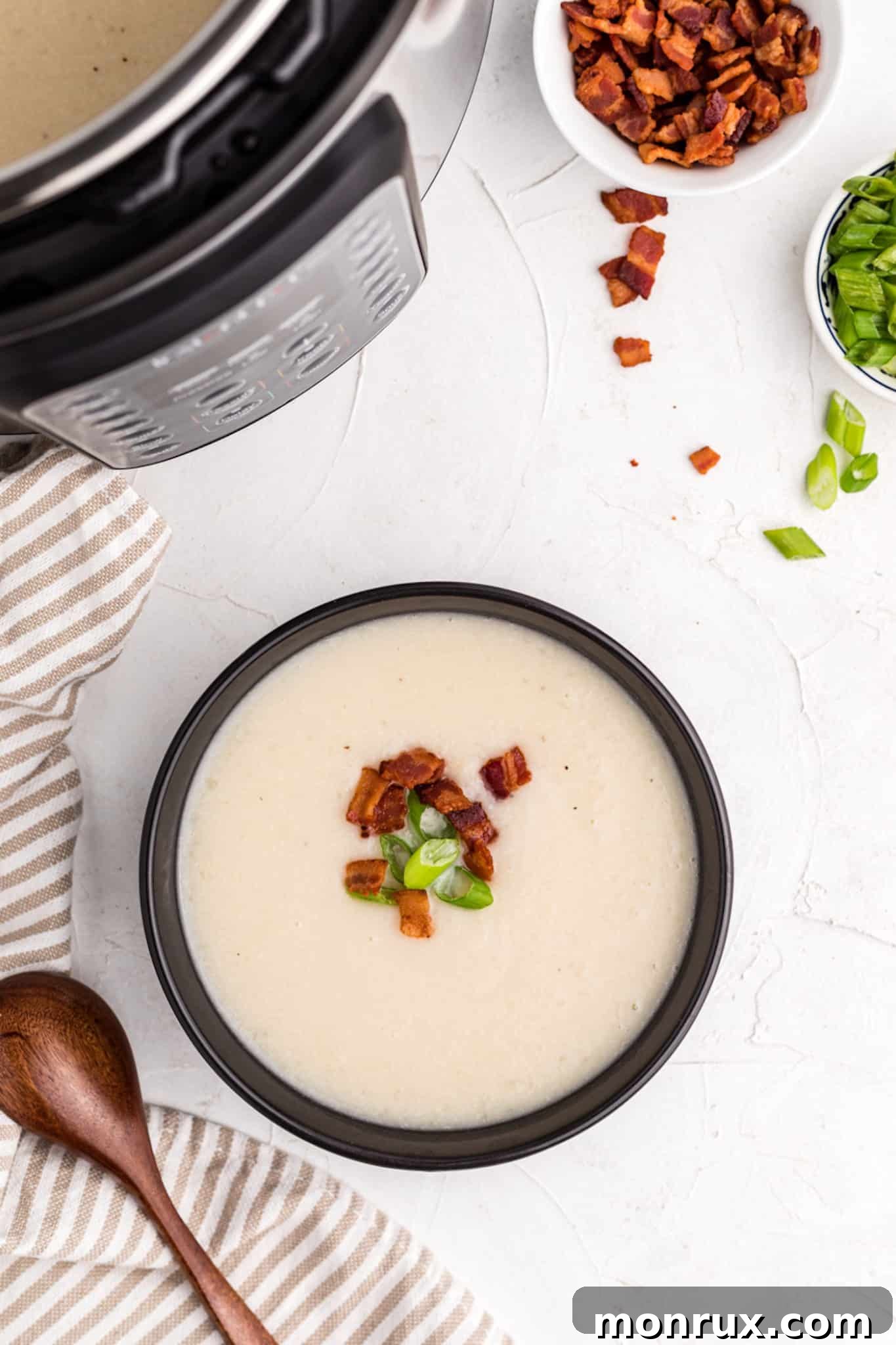 bowl of cauliflower soup next to an instant pot.
