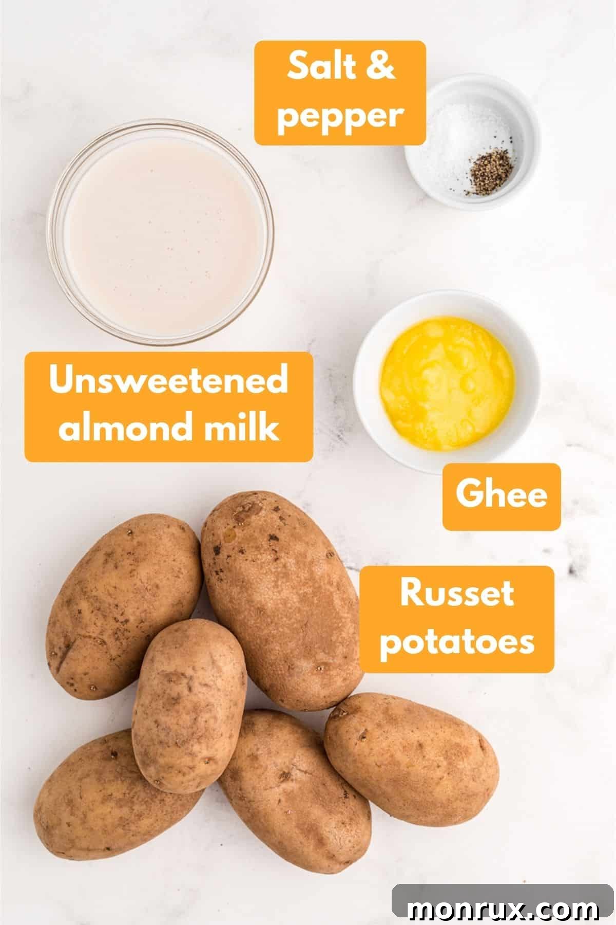 A selection of fresh ingredients including russet potatoes, ghee, and almond milk, laid out for making Whole30 mashed potatoes.