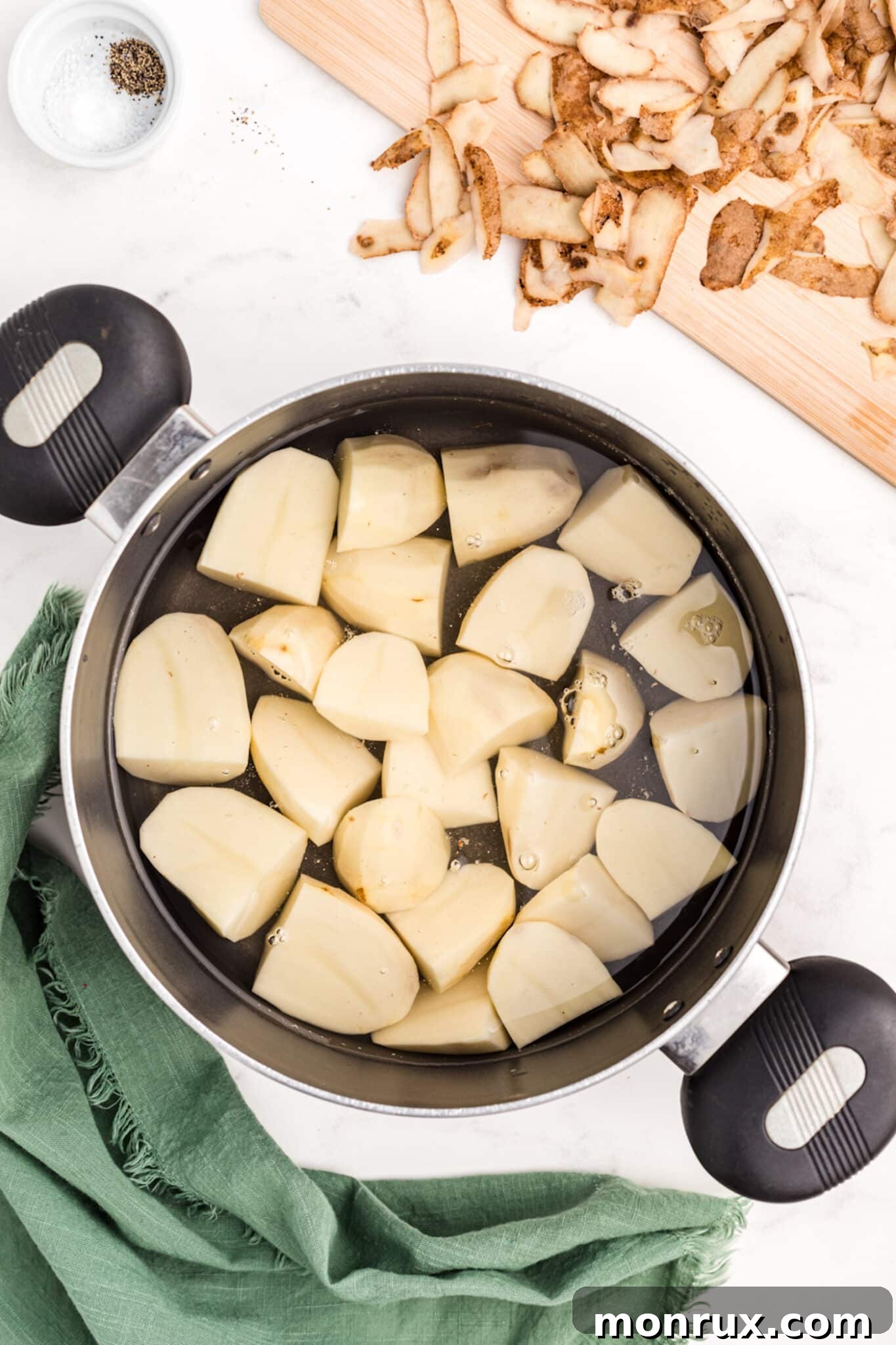 Potatoes boiling in a large pot on the stove.