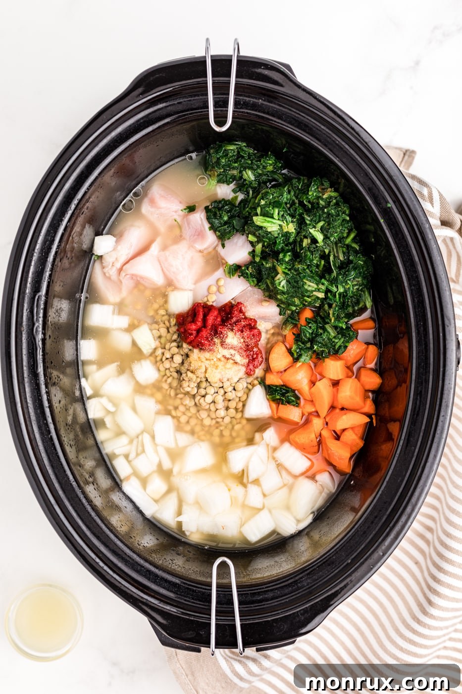 a slow cooker full of chicken, lentils, and veggies.