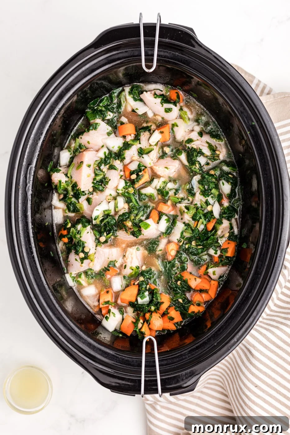 a crockpot with chicken, lentils, and veggies.