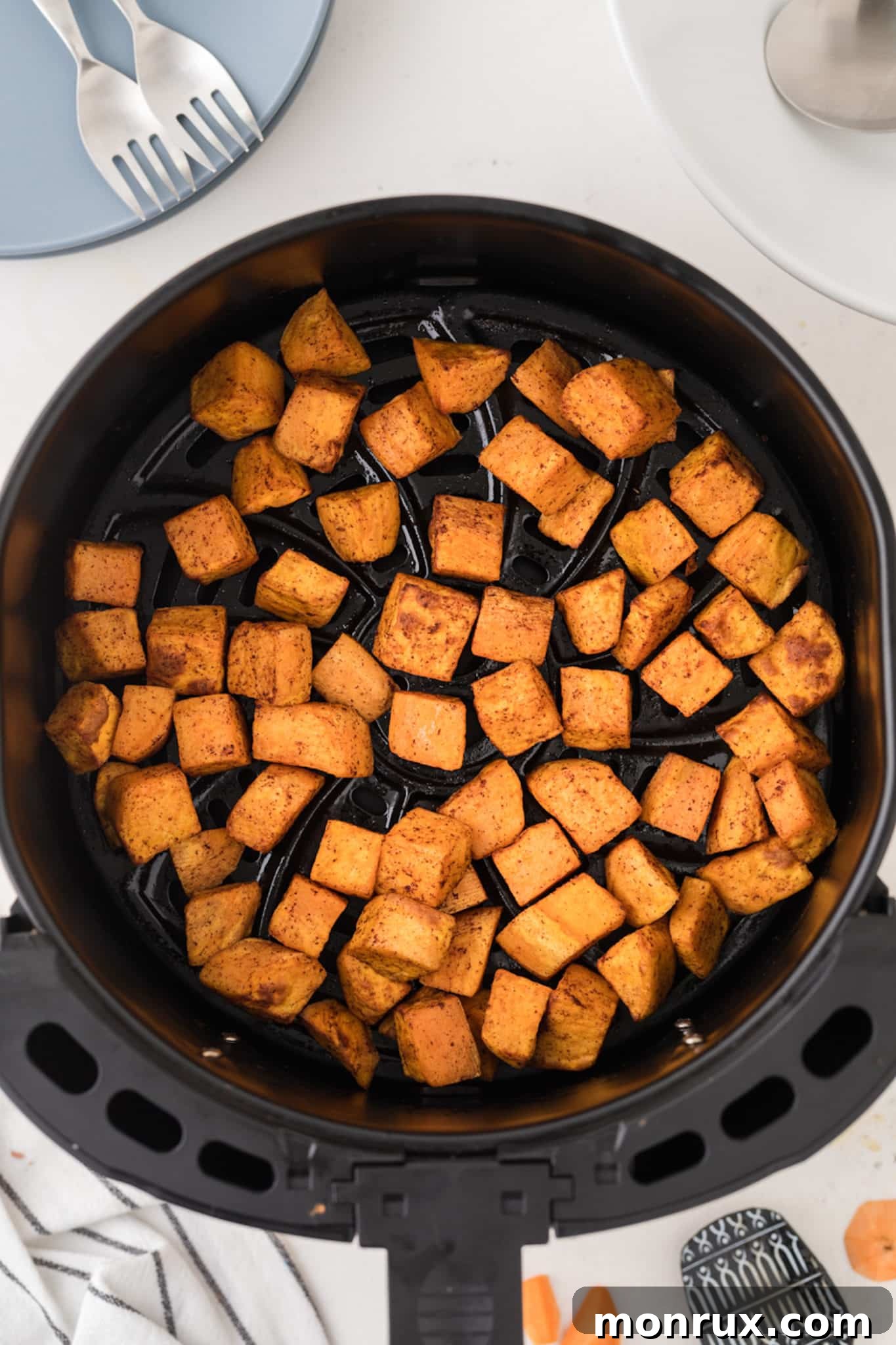 sweet potato cubes in an air fryer basket.