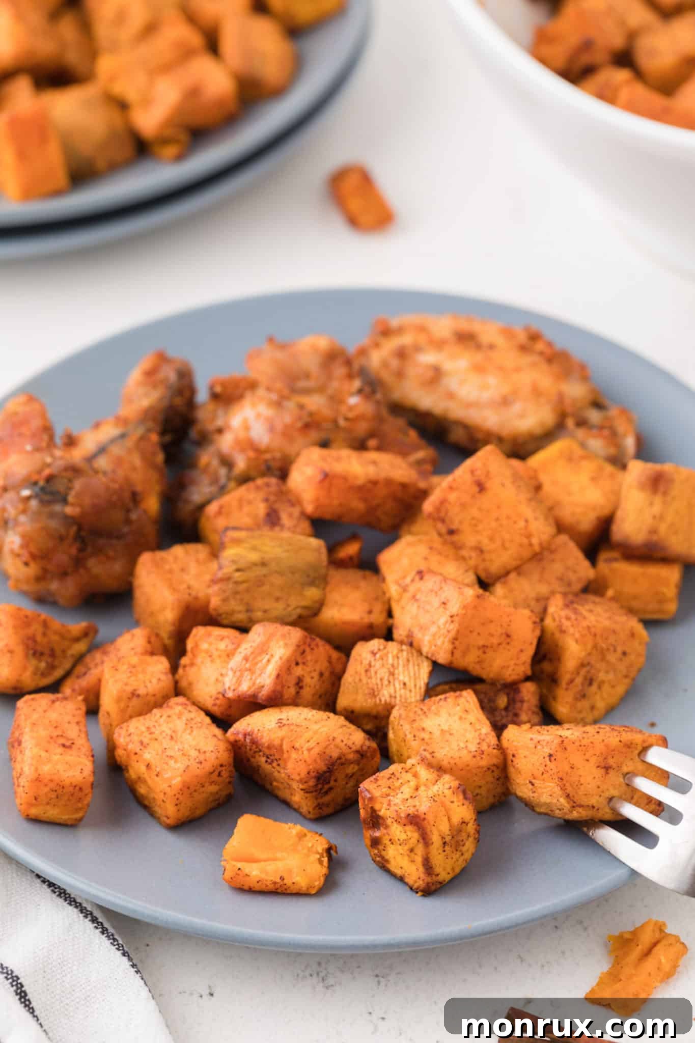 bowl of cooked sweet potato cubes on a blue plate.