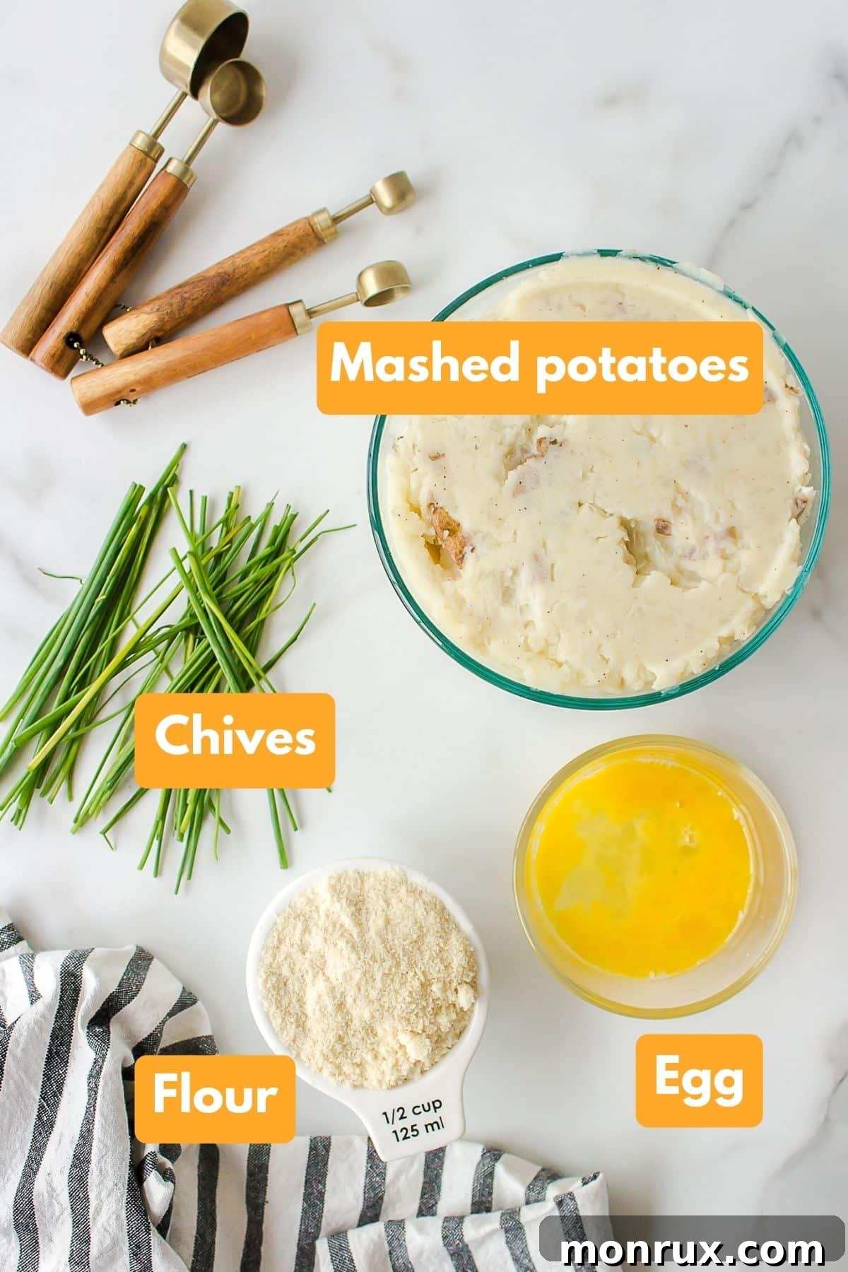 Individual ingredients laid out for making mashed potato fritters, including mashed potatoes, flour, egg, and chives.