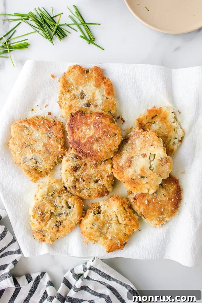 A plate of freshly fried, golden mashed potato fritters, ready for serving.