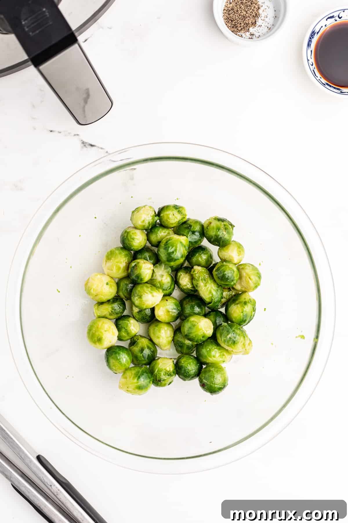 Frozen brussels sprouts in a mixing bowl, ready for air frying.