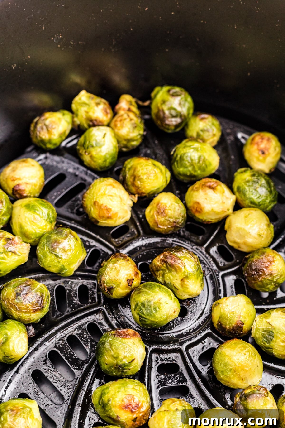 Perfectly air fried brussels sprouts, golden brown and crispy, in a serving bowl.